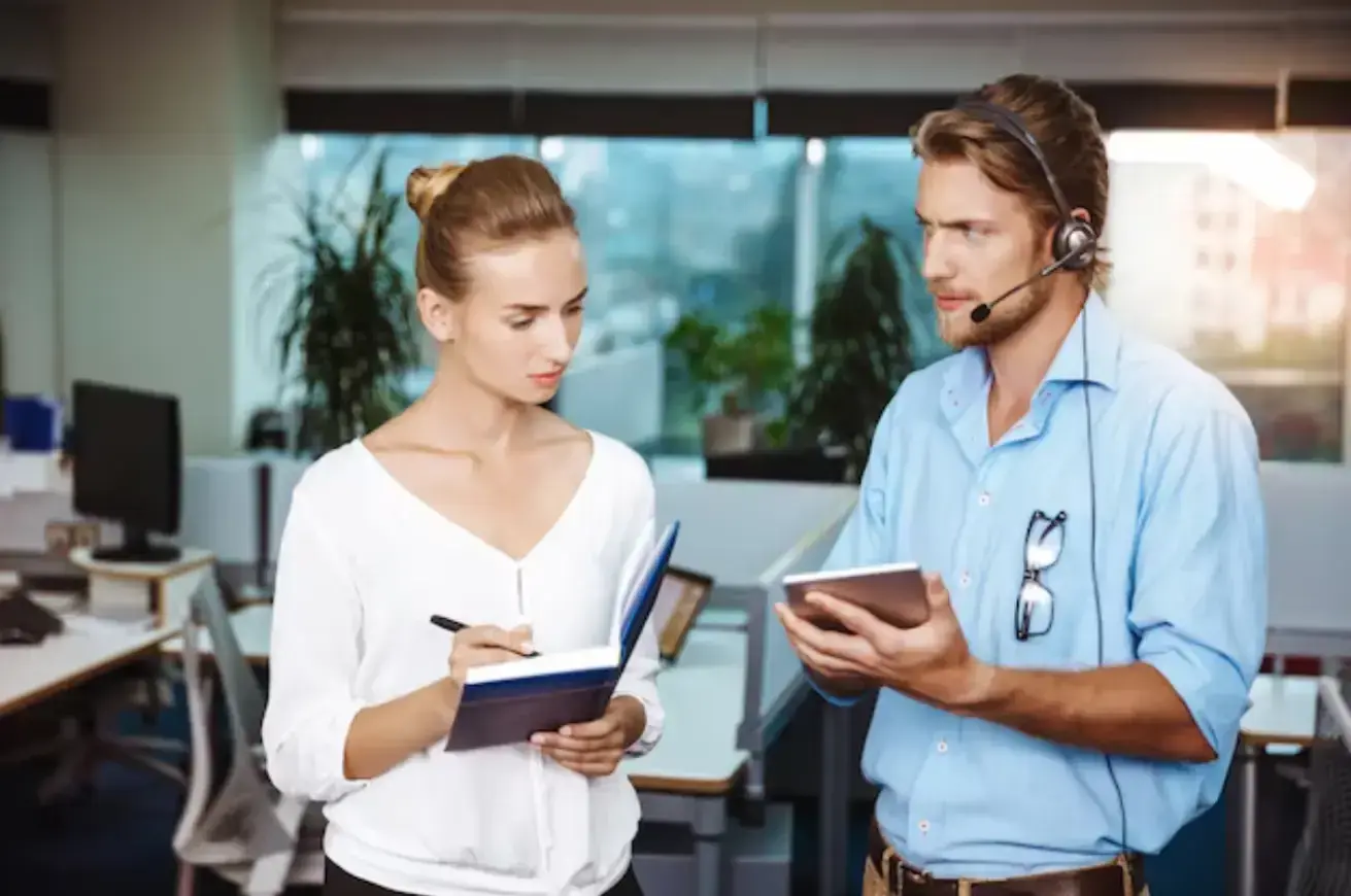 colleagues-smiling-speaking-holding-tablet-notebook-office