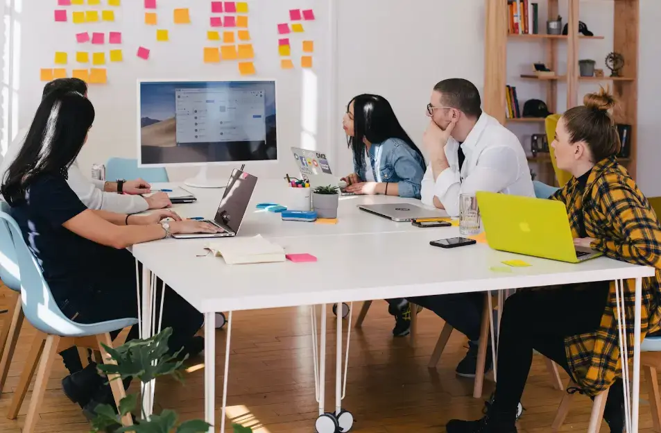 five-people-sitting-at-the-table-watching-turned-on-white-iMac