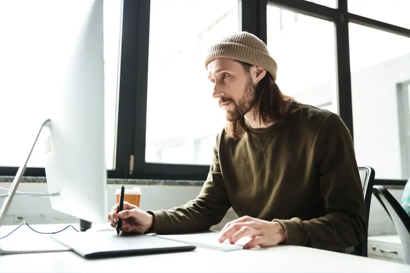 handsome-man-office-using-computer-looking-aside