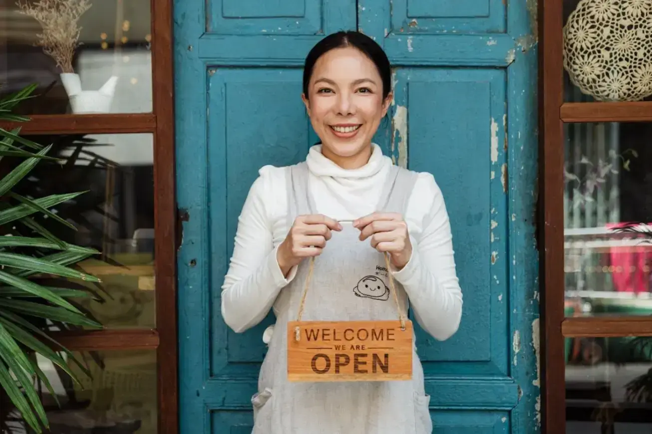 happy-business-owner-holding-welcome-we-are-open-sign
