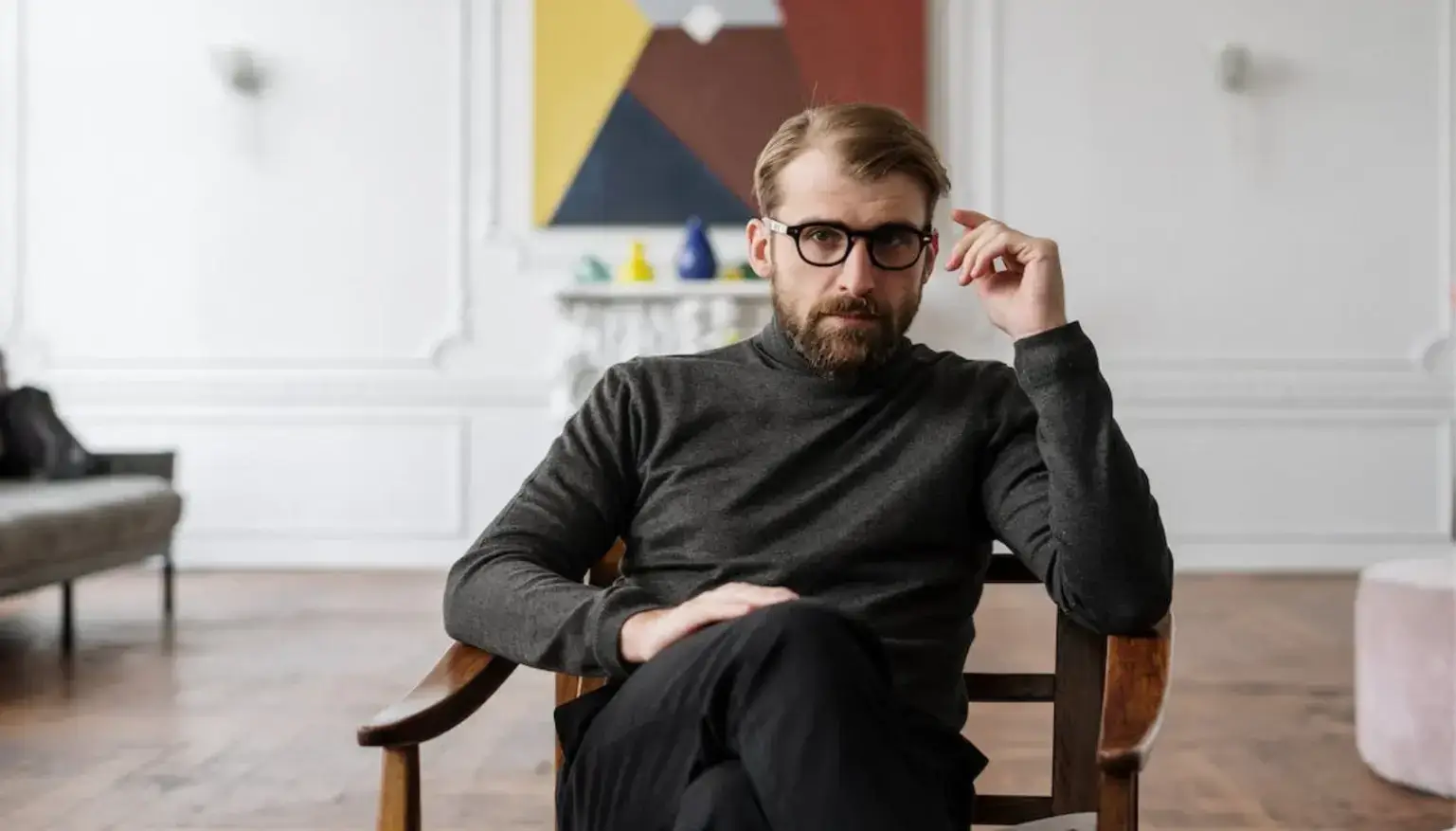 man-in-black-sweater-sitting-on-brown-wooden-chair