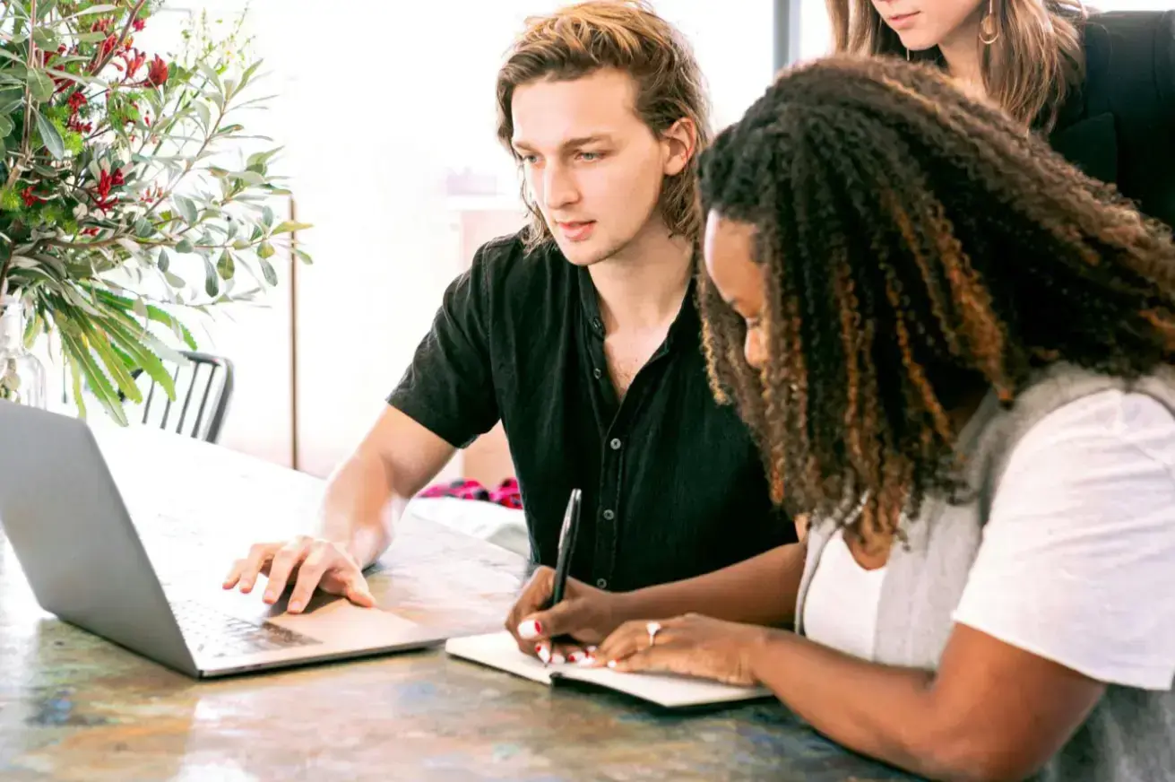 man-working-on-laptop-while-woman-takes-notes