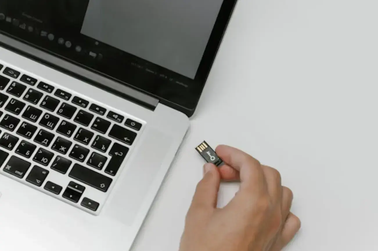 person-inserting-a-memory-card-into-a-laptop