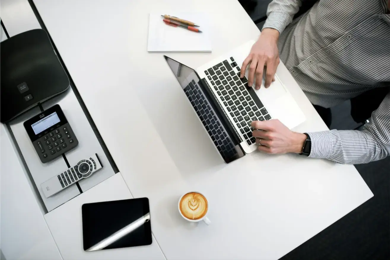 person-using-laptop-on-white-wooden-table