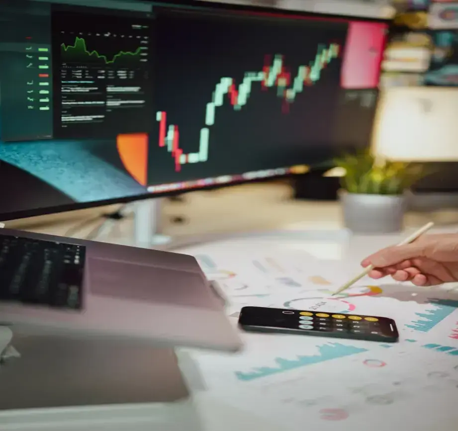 person-writing-on-a-piece-of-paper-next-to-a-computer-monitor