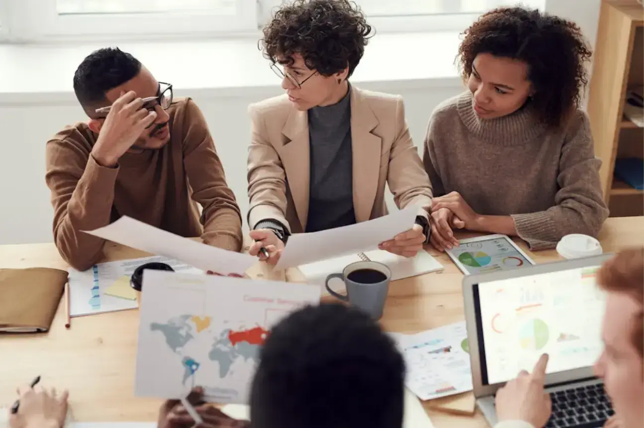 photo-of-people-sitting-near-table-holding-papers