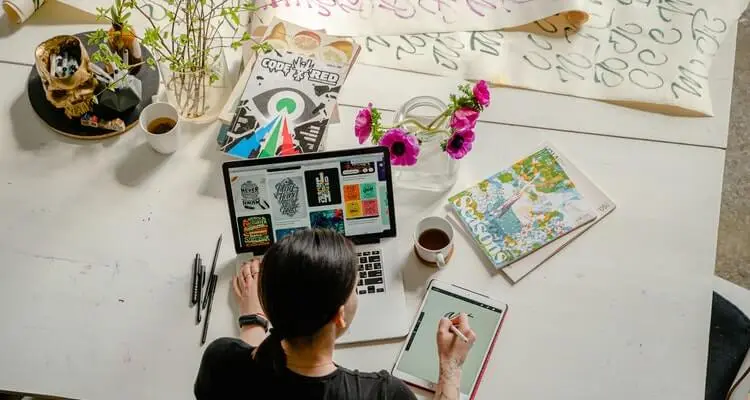 photo-of-woman-writing-on-tablet-computer-while-using-laptop-4348401