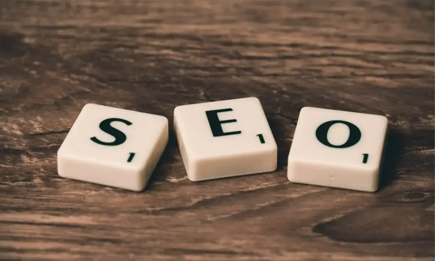 three-white-and-black-scrabble-tiles-on-brown-wooden-surface-1