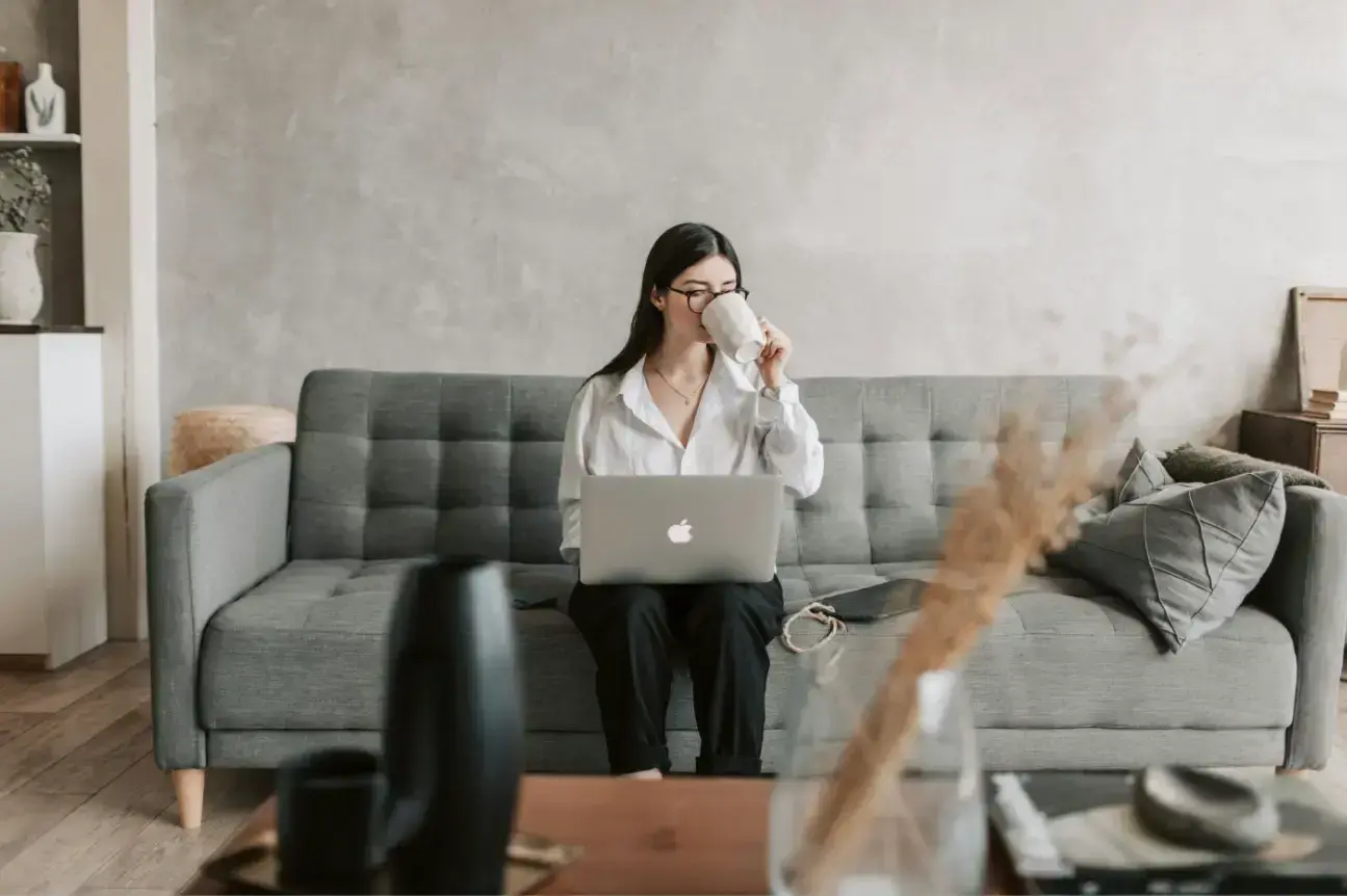 woman-drinking-coffee-while-working-with-laptop